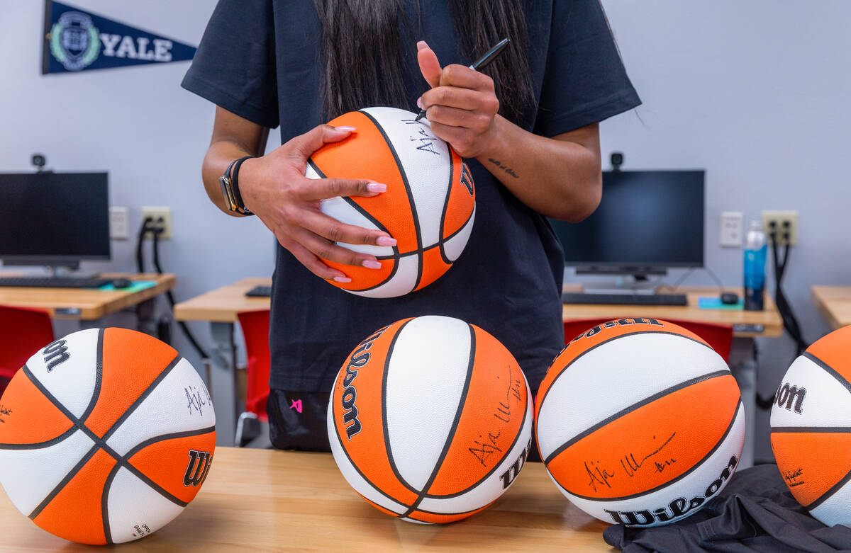 Aces star A'ja Wilson signs autographed basketballs to be given away as the A'ja Wilson and 2K ...