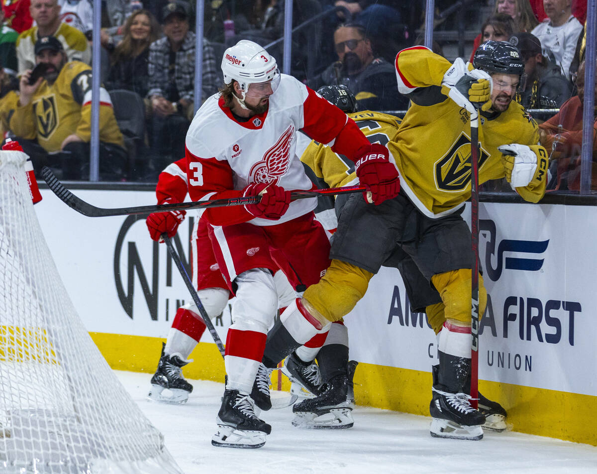 Detroit Red Wings defenseman Justin Holl (3) checks Golden Knights center Tomas Hertl (48) into ...