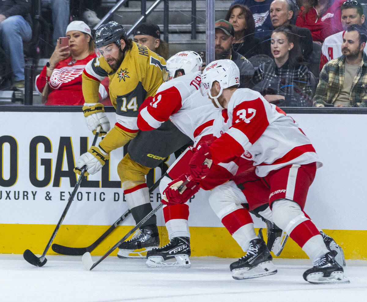 Golden Knights defenseman Nicolas Hague (14) is checked by Detroit Red Wings right wing Vladimi ...