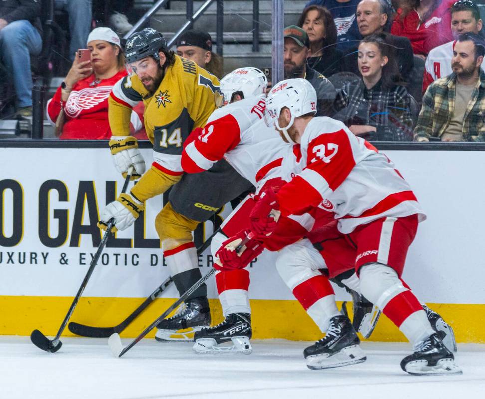 Golden Knights defenseman Nicolas Hague (14) is checked by Detroit Red Wings right wing Vladimi ...