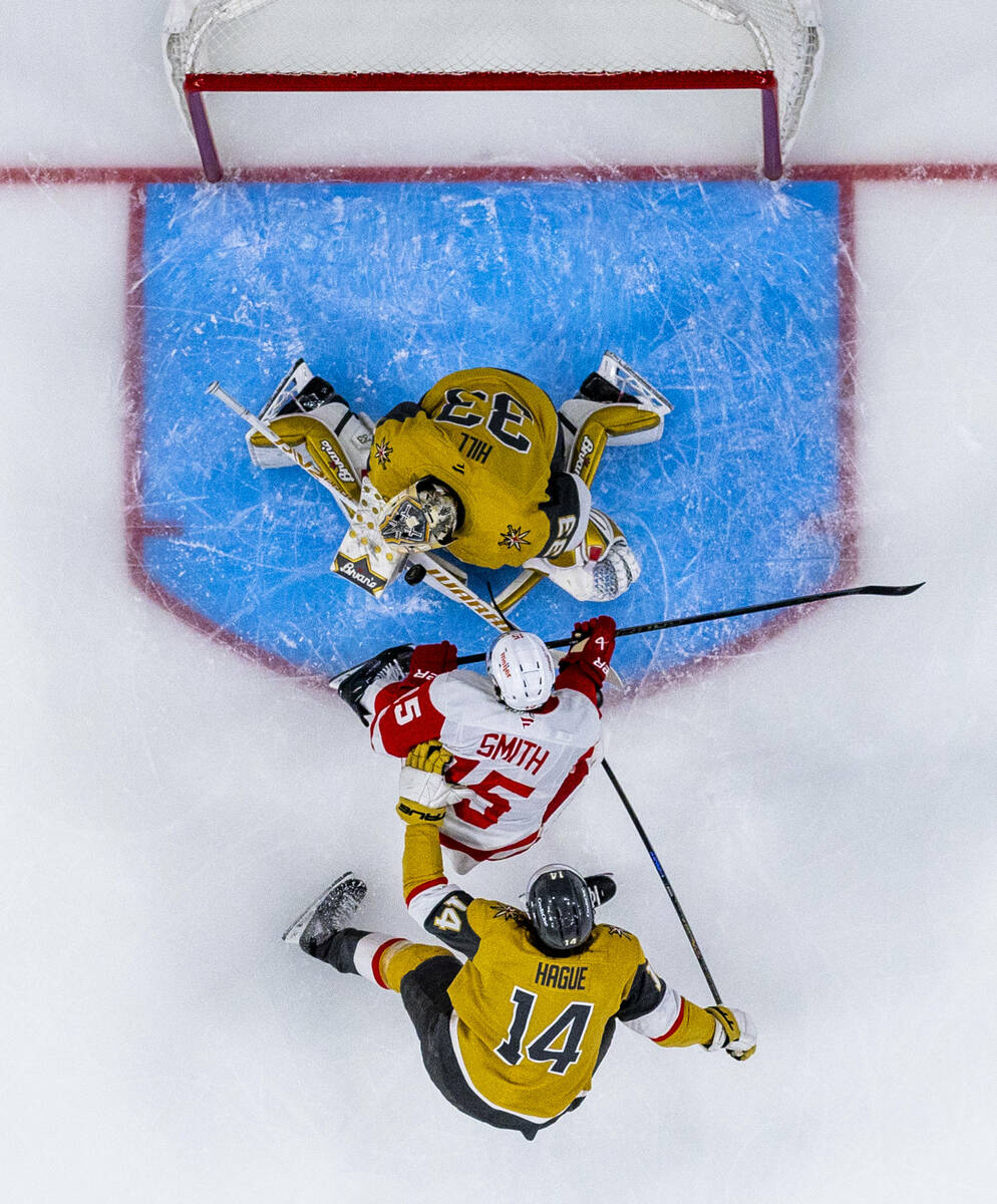 Golden Knights goaltender Adin Hill (33) deflects a shot from Detroit Red Wings center Craig Sm ...