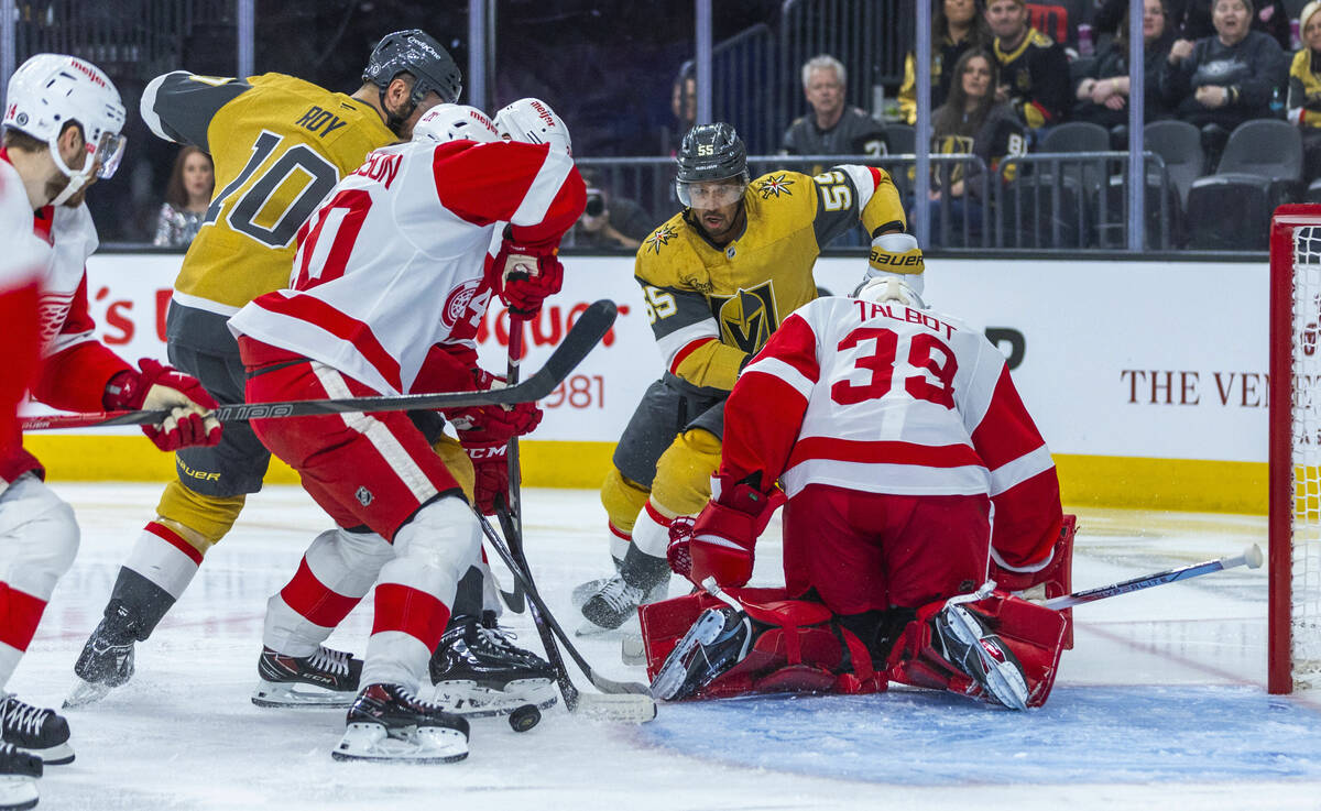 Golden Knights center Nicolas Roy (10) battles for the puck with Detroit Red Wings defenseman A ...
