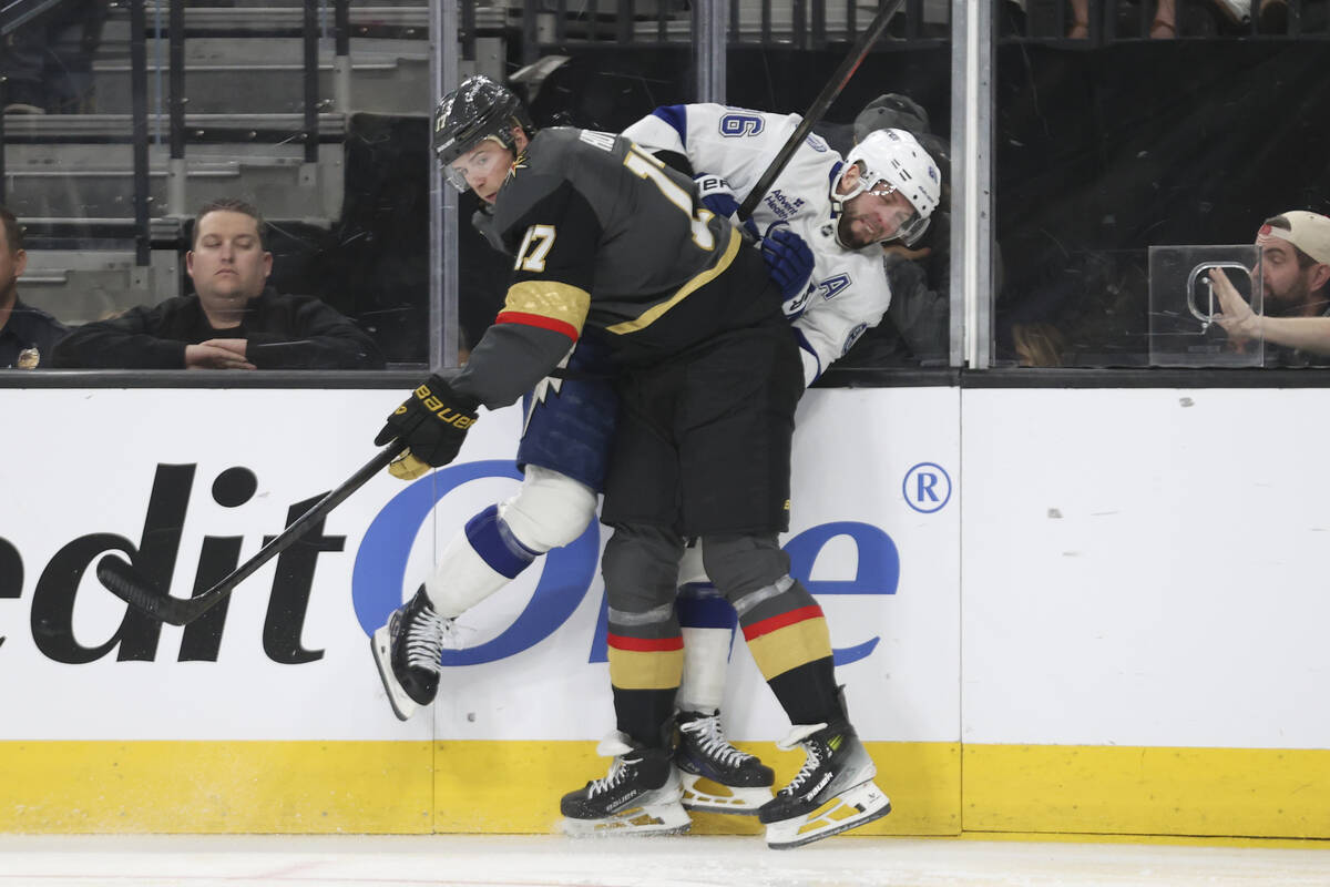 Vegas Golden Knights defenseman Ben Hutton (17) checks Tampa Bay Lightning right wing Nikita Ku ...