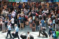 Travelers wait in line for security in the east hall atrium at Orlando International Airport, T ...