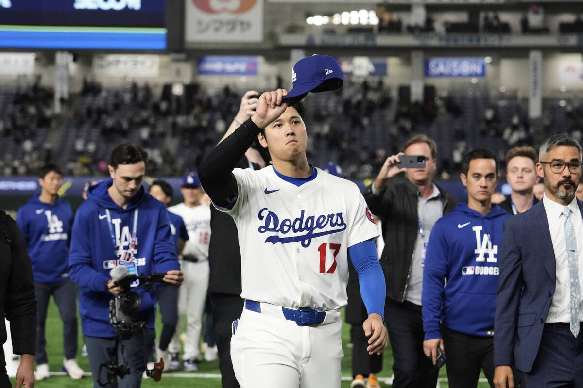 Los Angeles Dodgers' Shohei Ohtani waves to fans as he walks off the field after the team's MLB ...