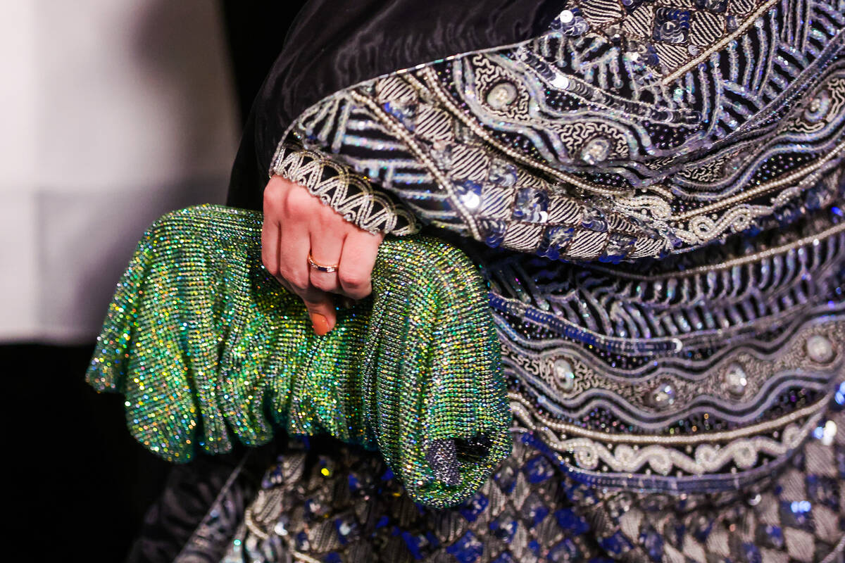 An attendee holds a purse on the blue carpet at the One Night for One Drop event hosted by the ...