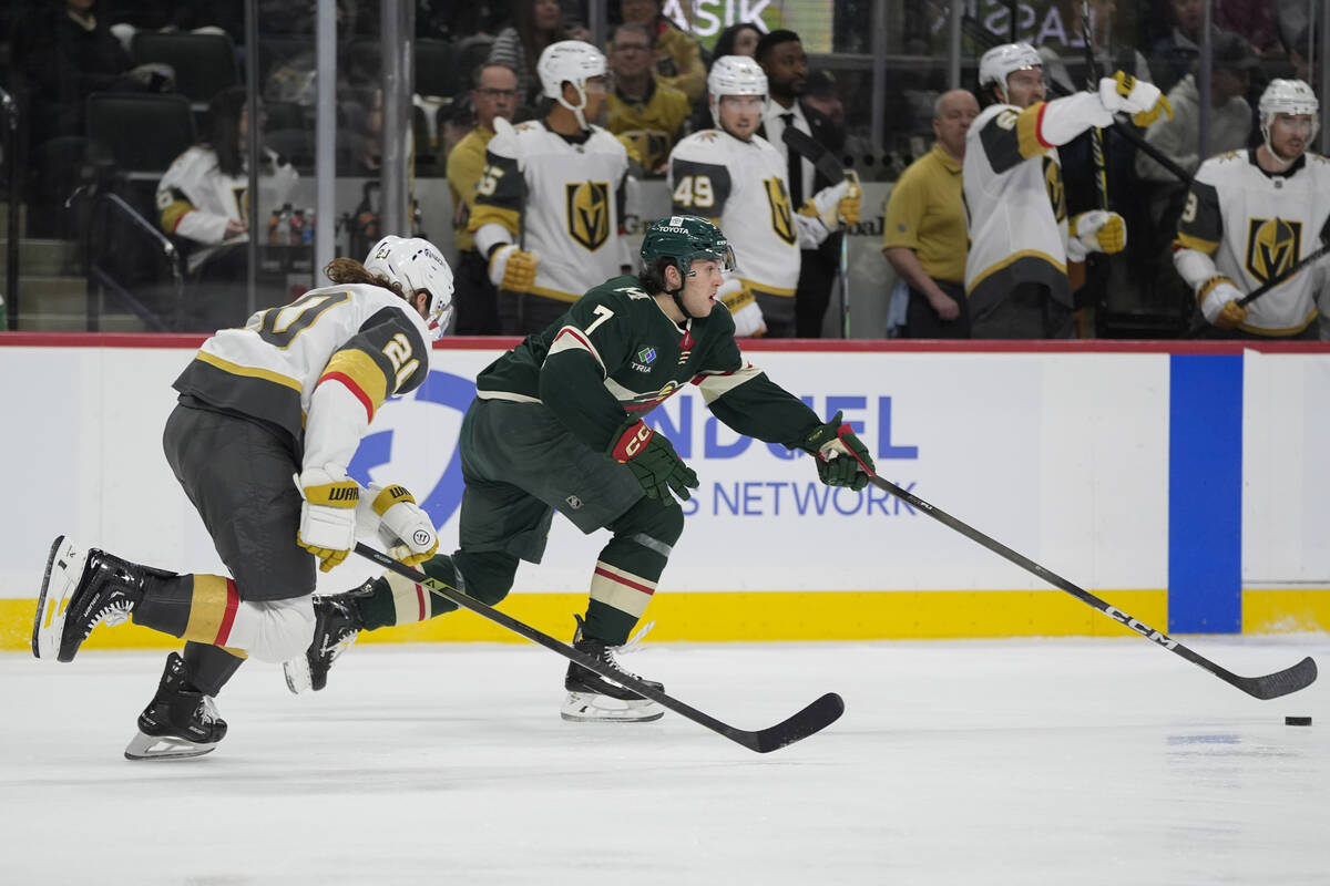 Minnesota Wild defenseman Brock Faber (7) skates with the puck as Vegas Golden Knights left win ...