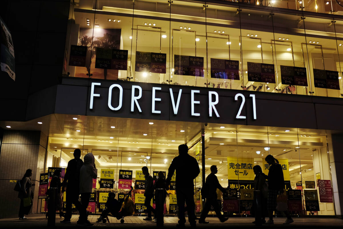 Shoppers walk by a Forever 21 clothing store, Thursday, Oct. 24, 2019, in Tokyo, as liquidation ...