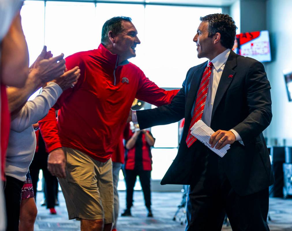 New UNLV men's basketball coach Josh Pastner greets head football coach Dan Mullen at an introd ...