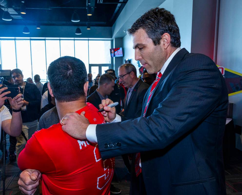 New UNLV men's basketball coach Josh Pastner signs his autograph on a fan's shirt during an int ...