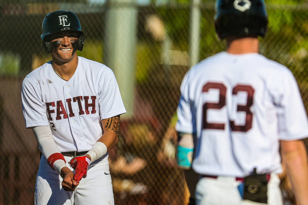 Faith Lutheran infielder Kingston Kela (2) smiles as he gets ready to walk to first base during ...
