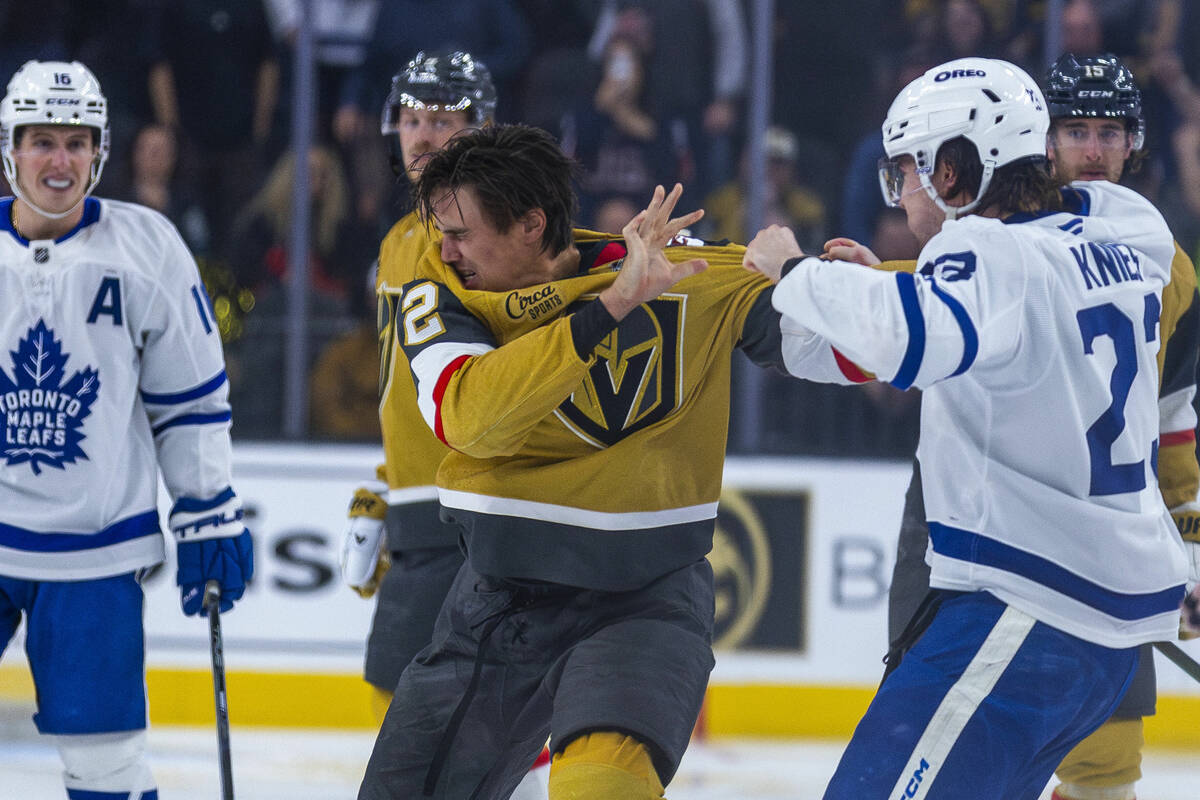 Golden Knights defenseman Zach Whitecloud (2) fights with Toronto Maple Leafs defenseman Simon ...