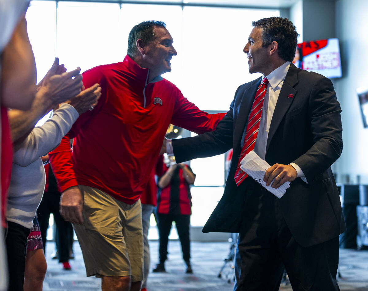 New UNLV men's basketball coach Josh Pastner greets head football coach Dan Mullen at an introd ...