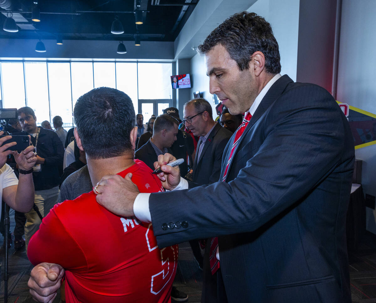 New UNLV men's basketball coach Josh Pastner signs his autograph on a fan's shirt during an int ...