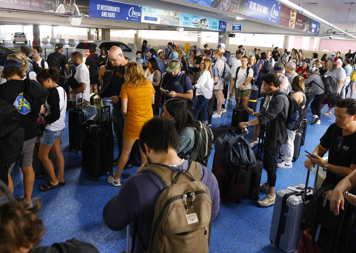 Passengers wait in the Uber and Lyft pick up area at Harry Reid International Airport Friday, M ...