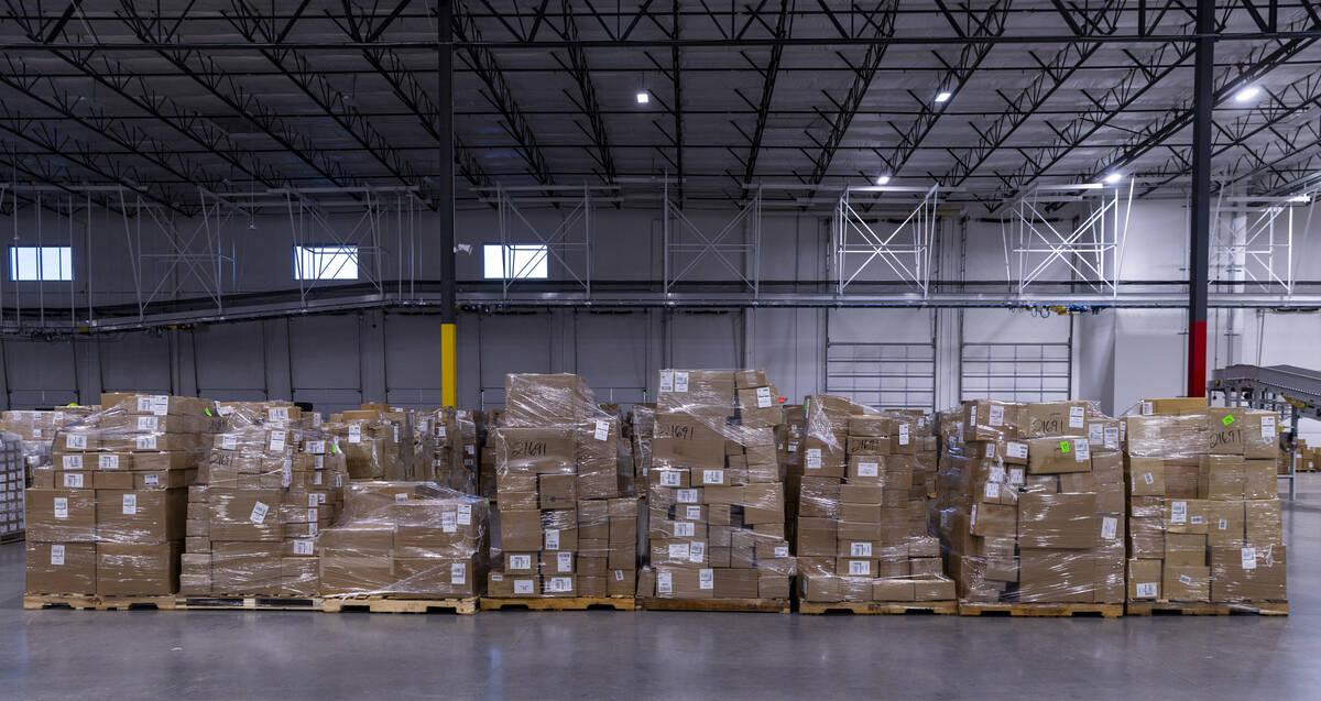Bundles of packages are stored temporarily at pattern during a tour of the new distribution fac ...