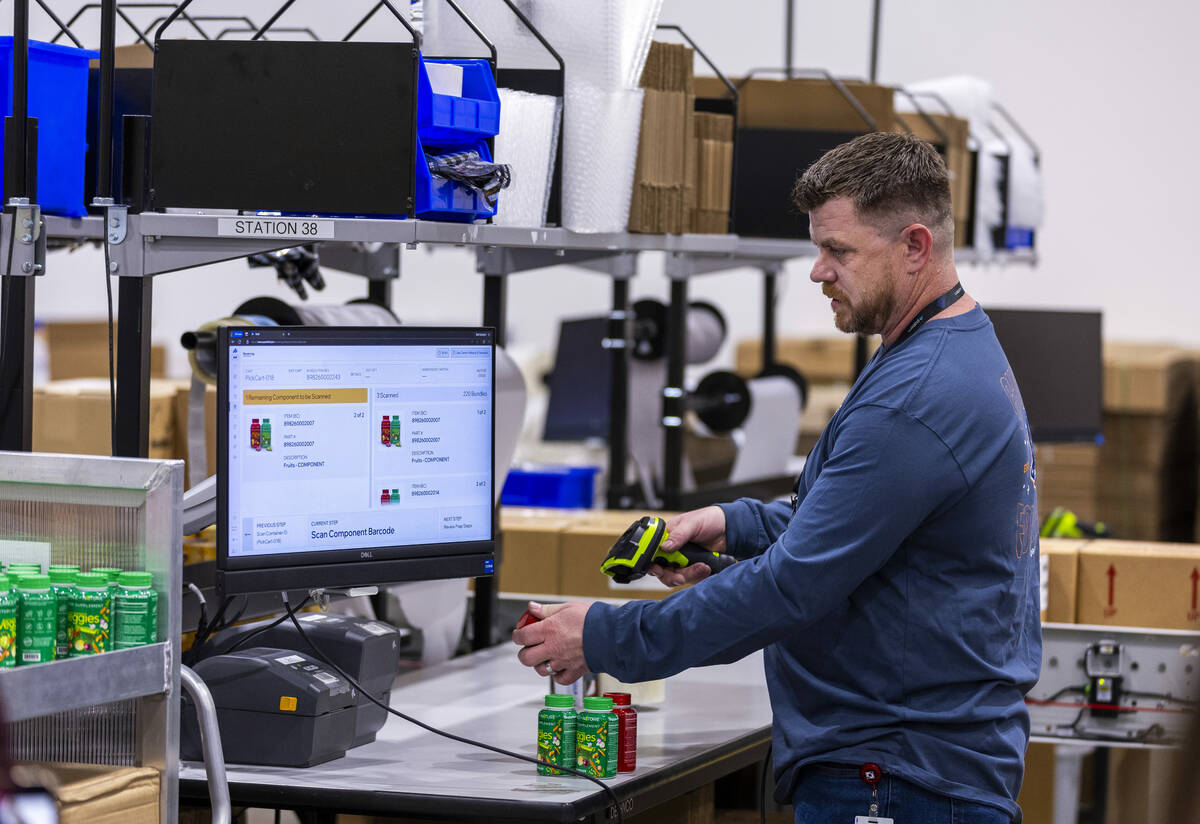 Shaun Mayo of Pattern demonstrates the sorting a labeling of products at a station in their war ...
