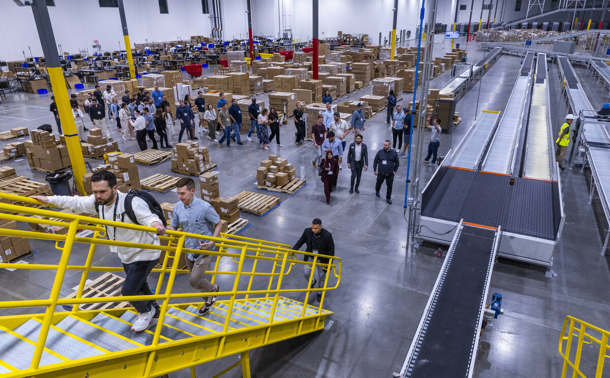 Invited guests lead by Pattern COO Rob Hahn head to the new sorting conveyor system during a to ...