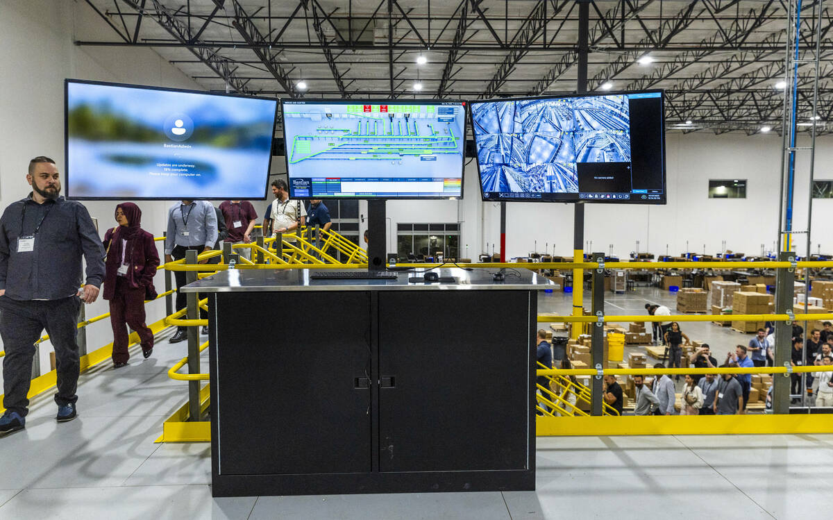 Invited guests observe their new sorting conveyor system during a tour of the new distribution ...
