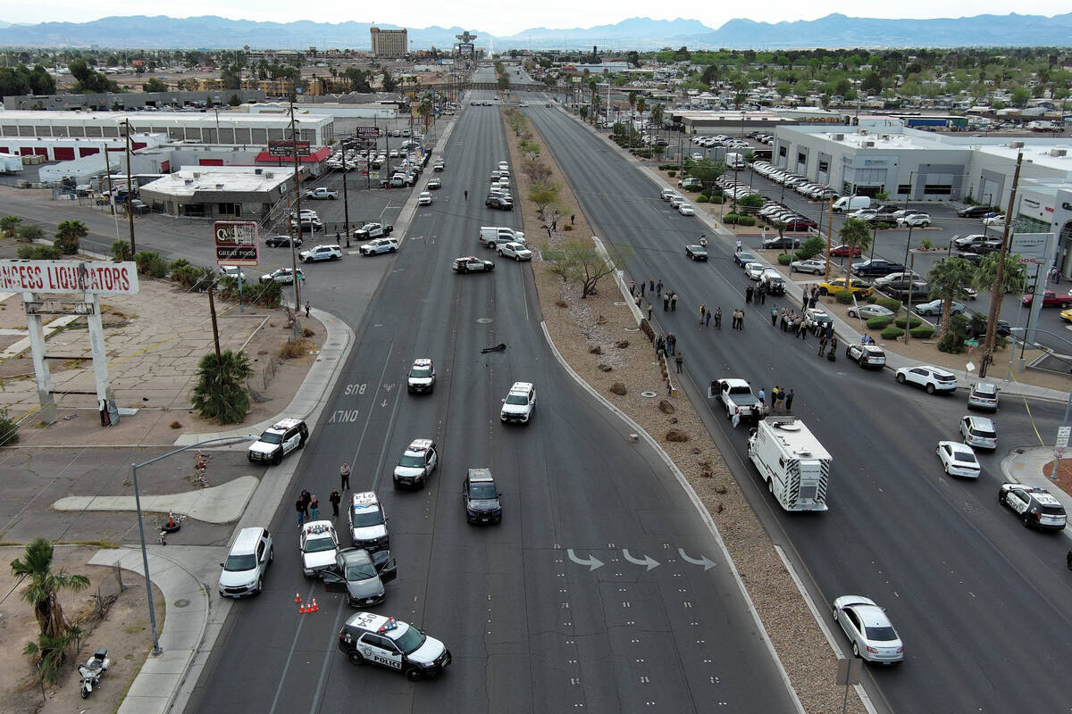 Police officers gather on Boulder Highway at Sahara Avenue where a murder suspect was apprehend ...