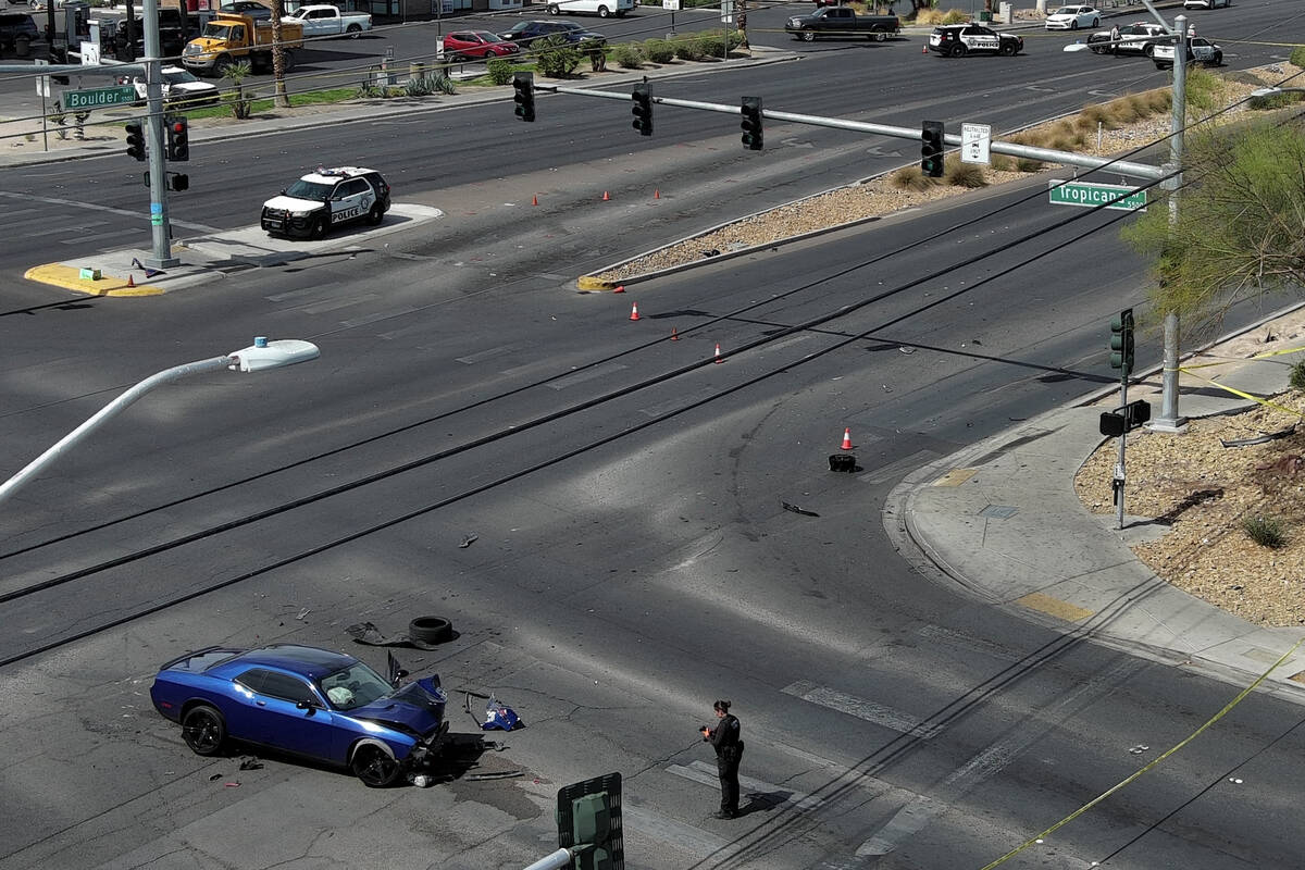A wrecked car is seen on Boulder Highway at Tropicana Avenue where a murder suspect crashed int ...