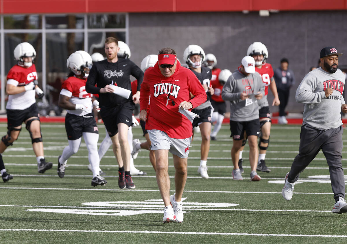 UNLV football head coach Dan Mullen and his players take the field during team practice, on Thu ...