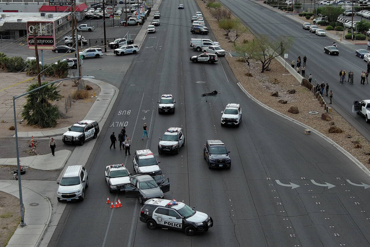 Police officers gather on Boulder Highway at Sahara Avenue where a murder suspect was apprehend ...