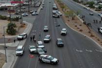 Police officers gather on Boulder Highway at Sahara Avenue where a murder suspect was apprehend ...