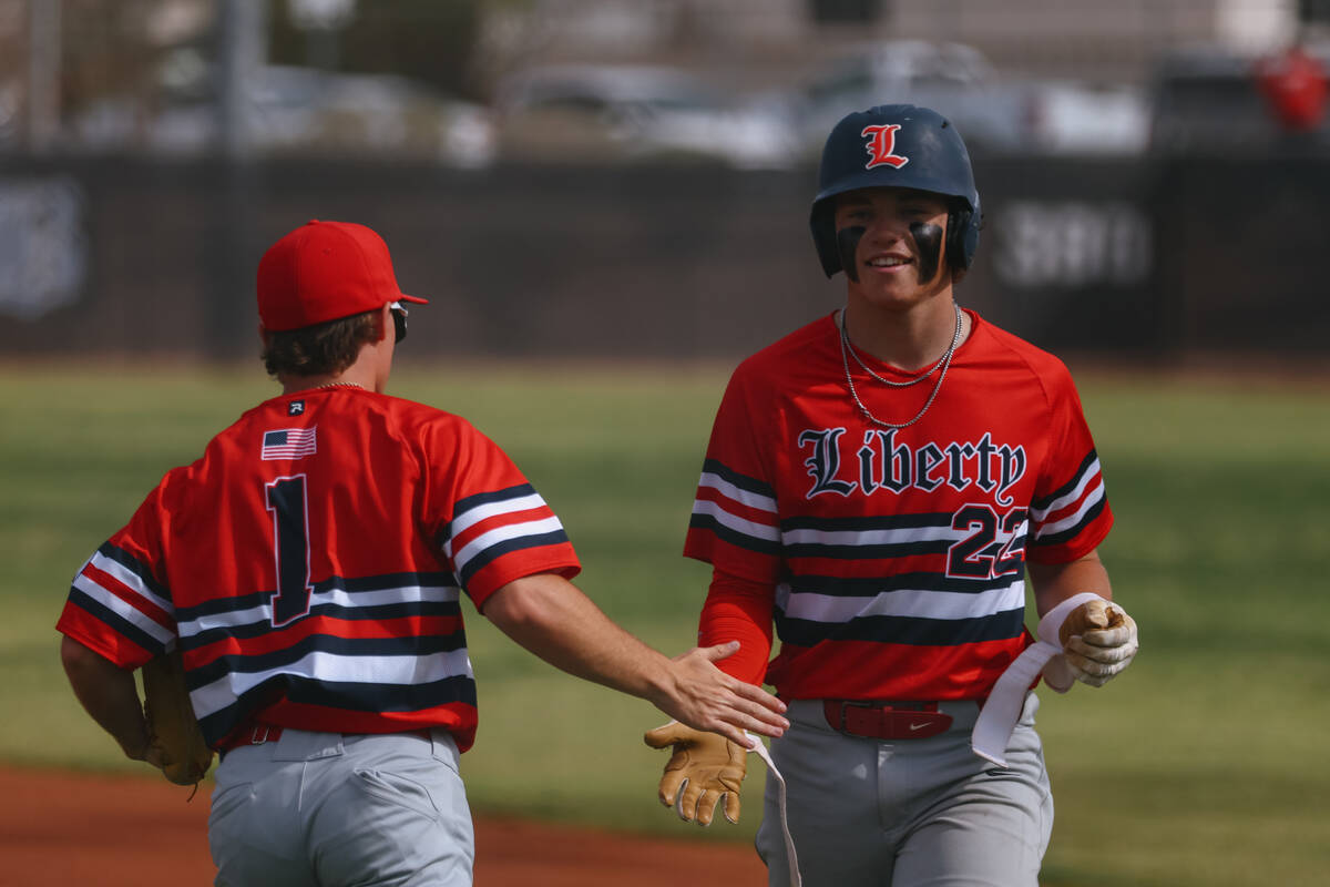 Liberty’s Chris Onoszko (1) and Grant Kelly (22) slap hands after 22 was put out, ending ...