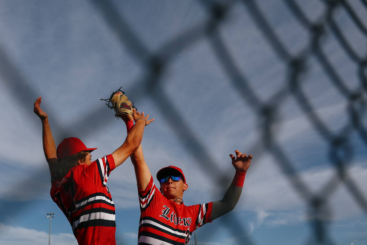 Liberty’s Carter Brunson (17) and Nicholas Blakeney (2) jump up to celebrate a third out ...