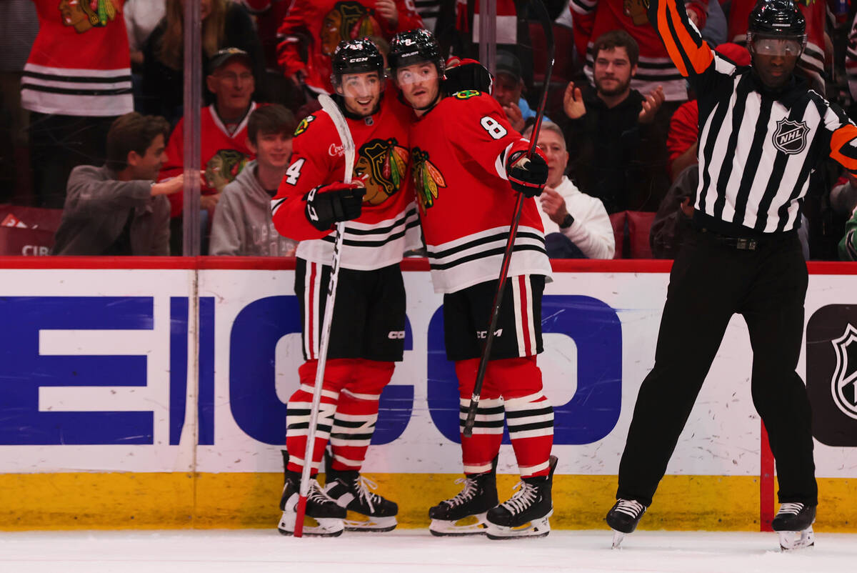 Chicago Blackhawks center Ryan Donato (8) celebrates with defenseman Wyatt Kaiser (44) after sc ...
