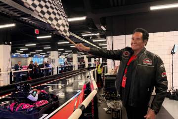 Wayne Newton waves the checkered flag to end the first karting race at F1 Drive inside Grand Pr ...