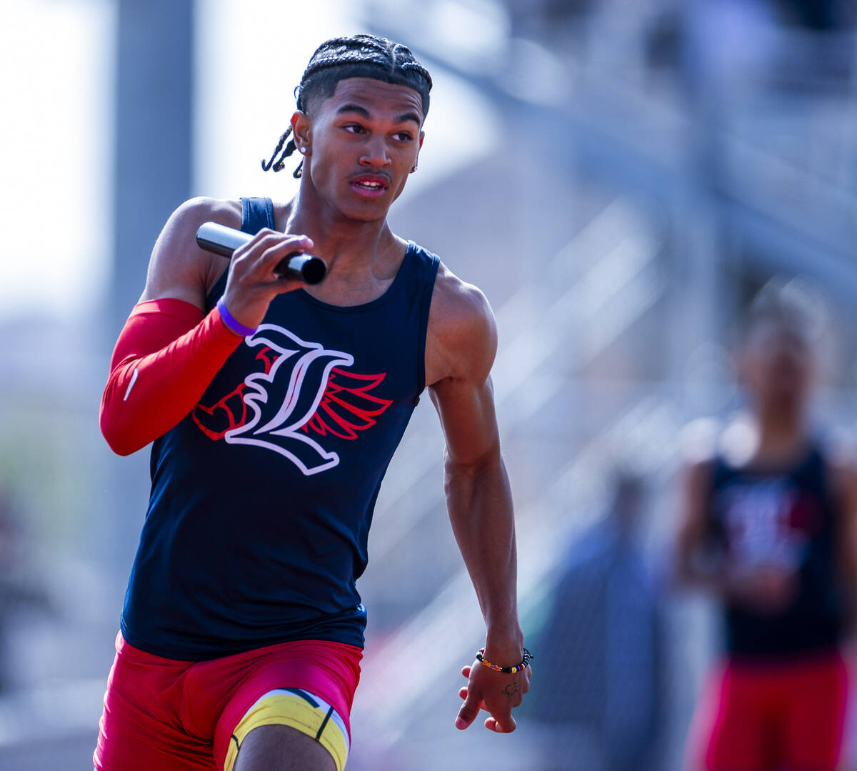 Liberty's Braylon Howard runs with the baton in the varsity mixed 4x200 relay race during the 2 ...