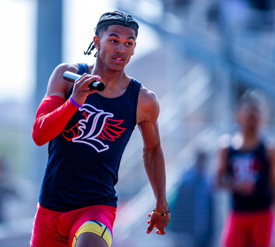 Liberty's Braylon Howard runs with the baton in the varsity mixed 4x200 relay race during the 2 ...