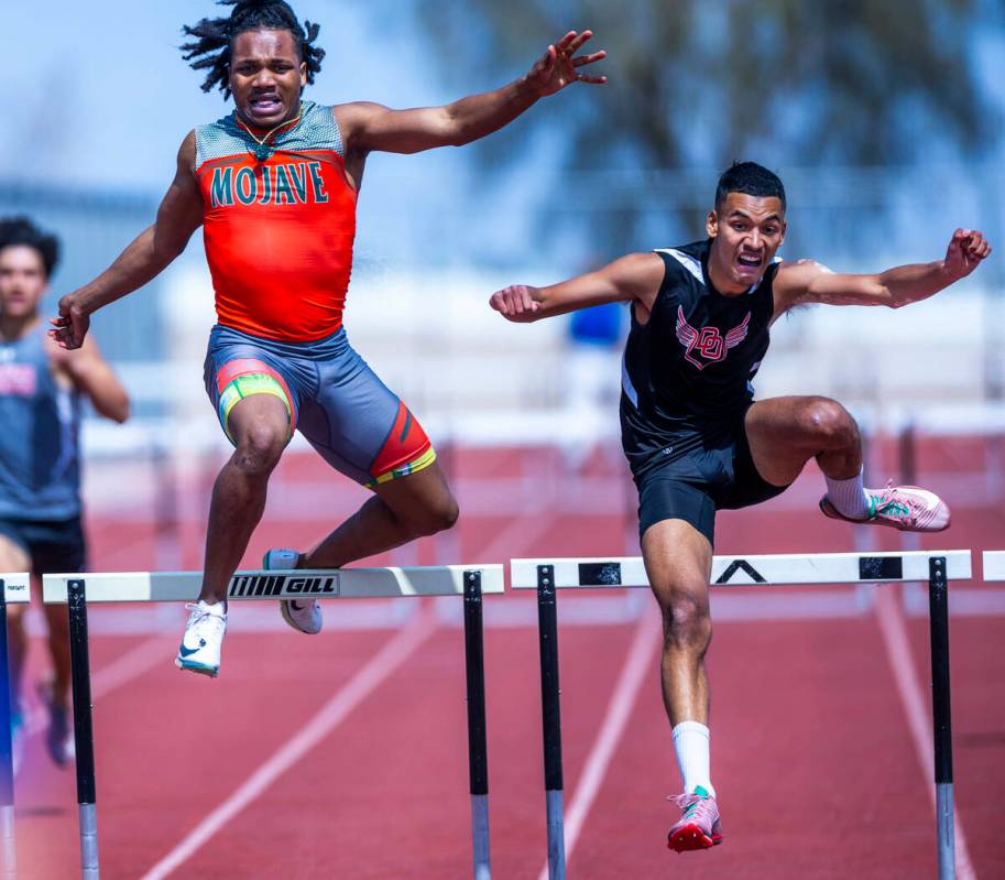 Mojave's Antwan Hawkins catches the hurdle and is thrown off as Desert Oasis' Noah Lara clears ...