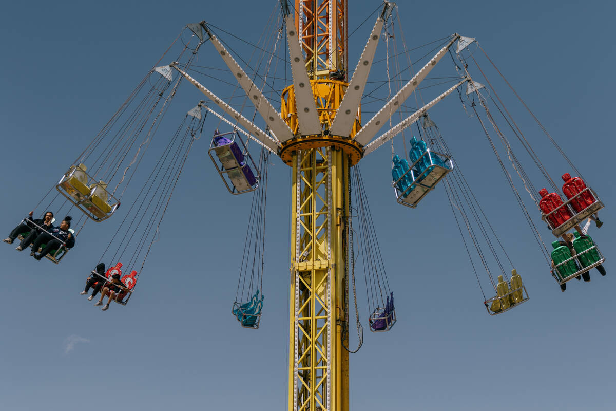 People take a high-flying spin on a ride during the Tacos and Tamales Festival on Saturday, Mar ...