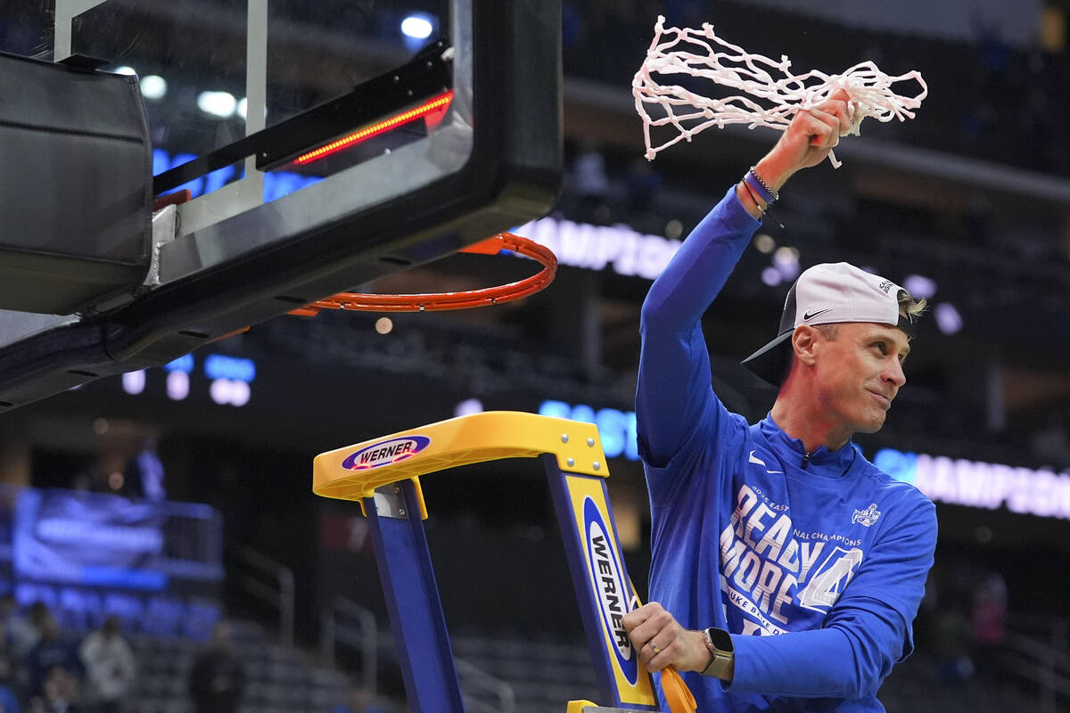Duke head coach Jon Scheyer waves the net after cutting the last piece after Duke defeated Alab ...