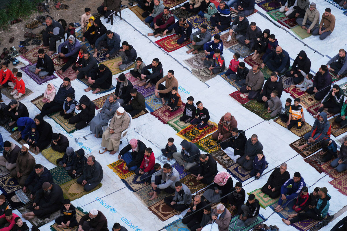 Palestinians attend Eid al-Fitr prayer in Deir al-Balah, Gaza Strip, Sunday, March 30, 2025. (A ...
