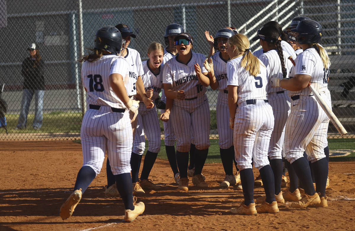 Shadow Ridge players cheer on Madison Foster (18), who got a home run, during a softball game a ...