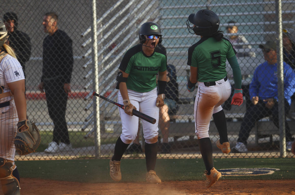Palo Verde's Halle Law, left, celebrates a run by Ava Cruz (5) during a softball game at Shadow ...