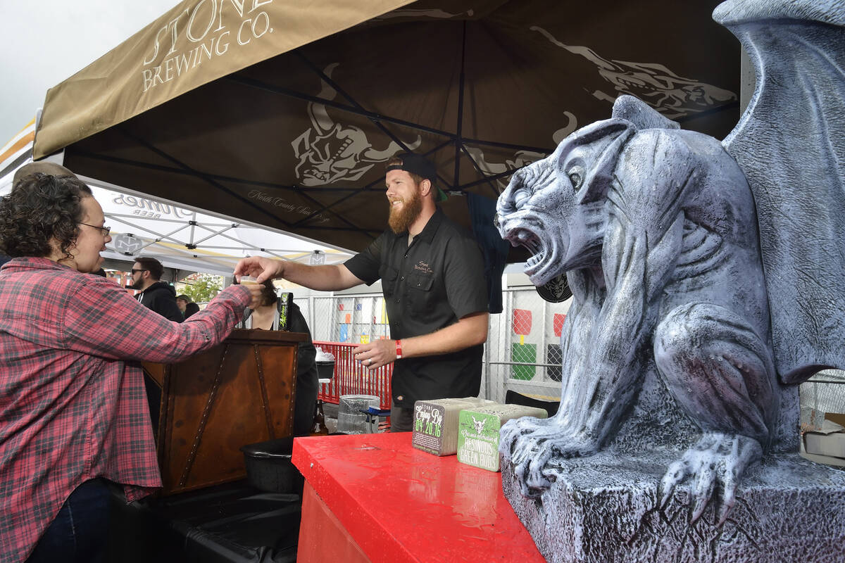 Adam Quinn hands a beer sample to a festivalgoer at the Stone Brewing company tent during the G ...