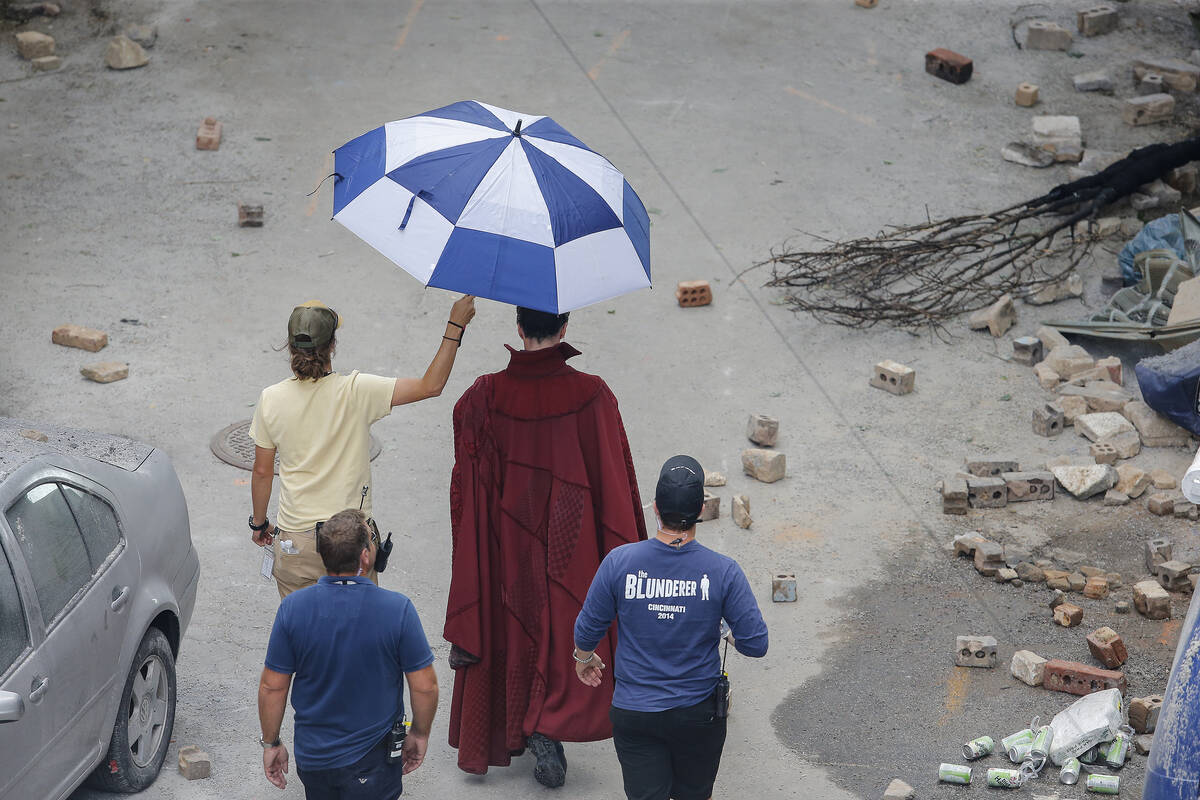 Cast member Benedict Cumberbatch, in red cape, walks to the set during the filming of "Ave ...