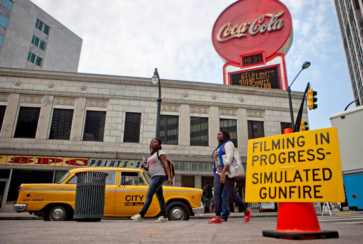 A sign warns people of simulated gunfire around downtown Peachtree Street during filming for t ...