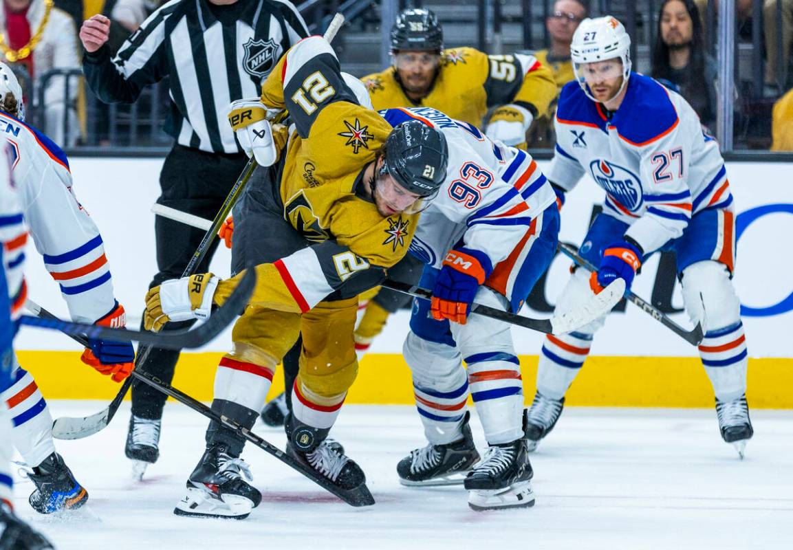 Golden Knights center Brett Howden (21) deflects a puck off his skate as he faces off with Edmo ...