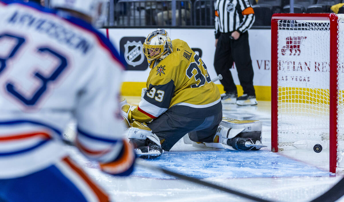 Golden Knights goaltender Adin Hill (33) looks back as an Edmonton Oilers shot scores past him ...