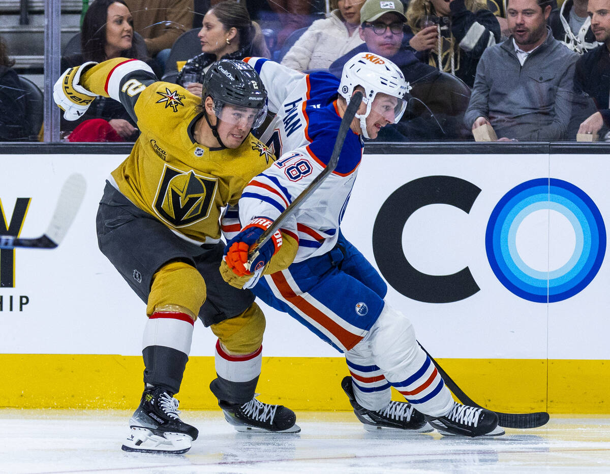 Golden Knights defenseman Zach Whitecloud (2) and Edmonton Oilers left wing Zach Hyman (18) bat ...