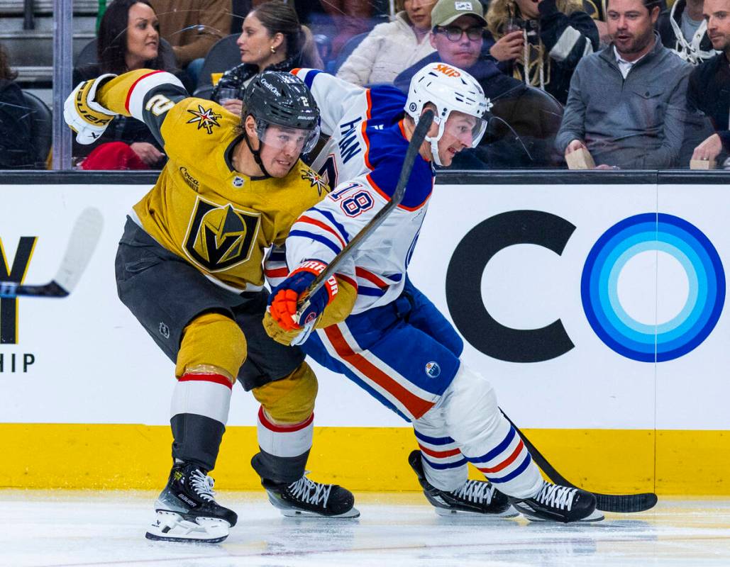 Golden Knights defenseman Zach Whitecloud (2) and Edmonton Oilers left wing Zach Hyman (18) bat ...