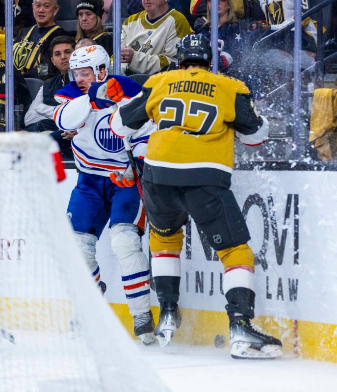 Edmonton Oilers left wing Zach Hyman (18) and Golden Knights defenseman Shea Theodore (27) batt ...