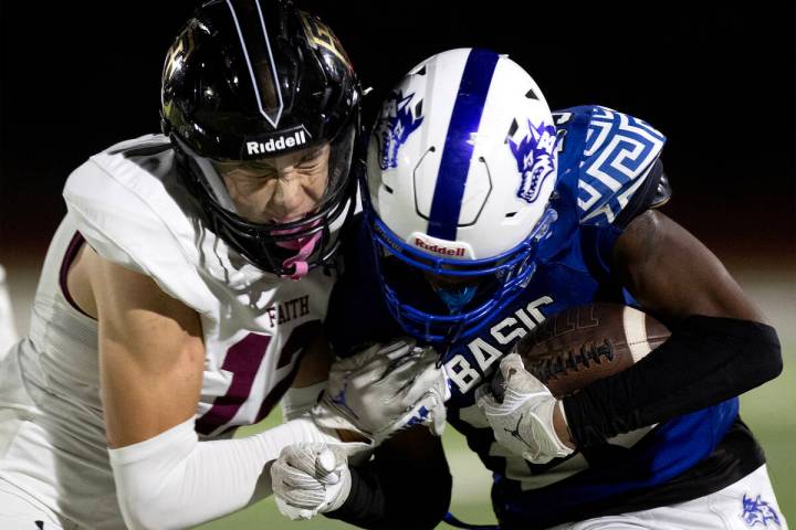 Faith Lutheran free safety Gavin Day (12) pushes Basic wide receiver Zuri Whiters (23) out of b ...