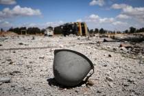 A helmet lies among the debris scattered at the site of an Israeli strike on a military airbase ...